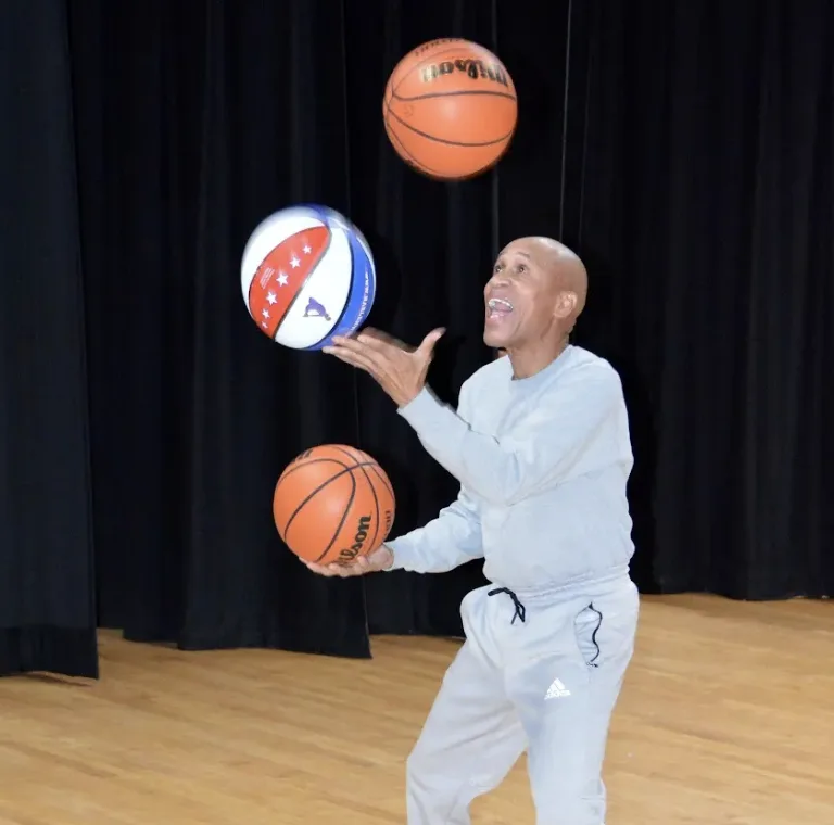 Man juggles 3 basketballs.